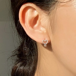 Minimalist 925 sterling silver heart stud earrings with beaded texture on earlobe