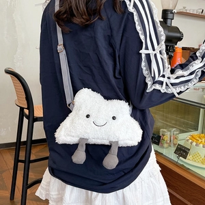 Cute white plush cloud crossbody bag with smiley face and corduroy legs on a model