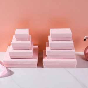 Elegant pink cross-pattern jewelry gift boxes in various sizes on marble surface