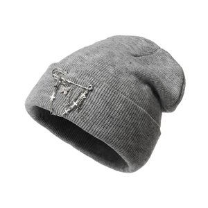 Close-up of grey knitted beanie with punk metal safety pins and butterfly chain charms