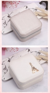 Detailed close-up of ivory PU leather jewelry box with zipper and Eiffel Tower charm
