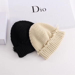 Black and beige knit beanies with frayed edges and ribbed texture for winter warmth