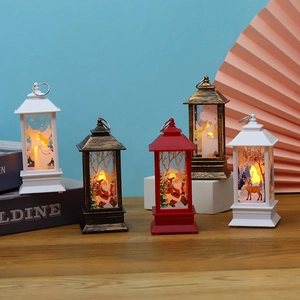 LED Christmas lanterns with Santa and Elk motifs on wooden table against blue wall