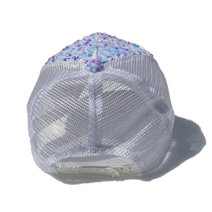 Detail view of breathable white mesh and shimmering blue-purple sequins on a trucker hat