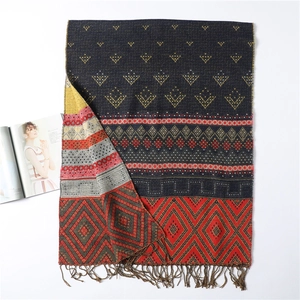 Detail shot of navy diamond lattice scarf featuring colorful tassels and ethnic patterns