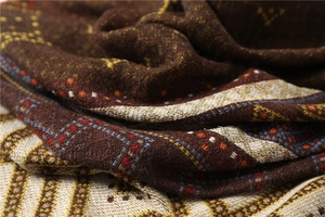 Macro shot showing the texture of dark brown and beige geometric lattice patterned shawl