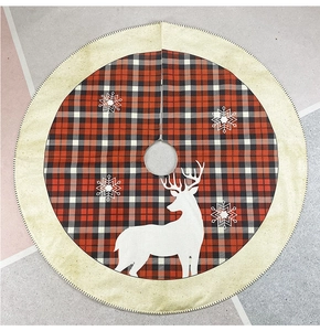 Close-up of burlap Christmas tree skirt with red plaid edges and white reindeer print