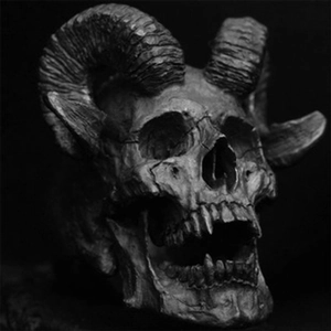 Macro shot of gothic silver skull sculpture with spiral horns and detailed bone texture