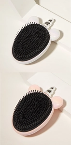 Close-up of white and pink unicorn hair brushes with black bristles on white platform