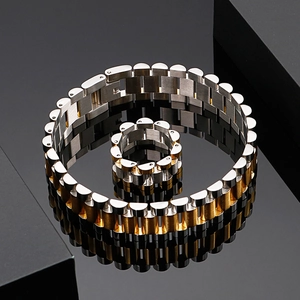 Detailed close-up of two-tone gold and silver stainless steel watch-style bracelet and ring