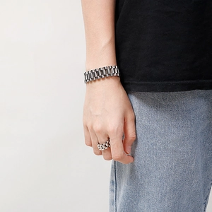 Detailed view of silver stainless steel watch-link bracelet and matching ring on model wrist