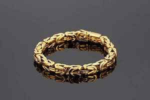 Vue détaillée d'un bracelet byzantin doré sur une surface réfléchissante grise