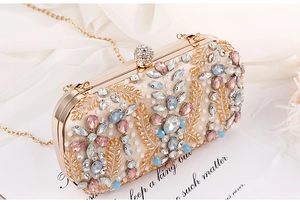 Detailed view of champagne evening bag with colorful gems, sequins and gold embroidery