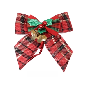 Detail of Christmas plaid bow with small gold bells, green leaves and red berries