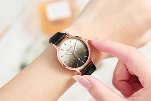 Detail of rose gold Milanese mesh magnetic strap and floral gradient watch face