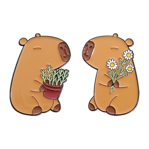 Set of two cartoon capybara enamel pins holding potted plant and white daisy flower