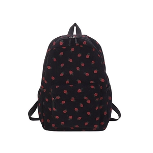 Detail of corduroy backpack texture with cute red strawberry patterns on black fabric