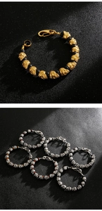 Detail of skull bead bracelet with tiger eye and lava stones on black background