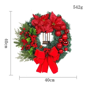 Christmas wreath with oil lamp, red poinsettias, pine needles, and berries decoration