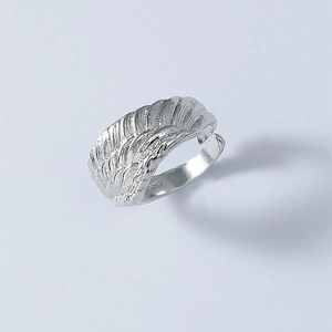 Macro detail of adjustable silver angel wing ring showing intricate feather textures