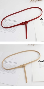 Detail of red and beige knotted PU leather skinny belts for dresses in a flat lay view