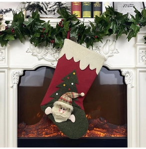 Detail of Christmas stocking with Santa Claus and tree decor hanging by a warm fireplace