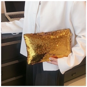 Close-up of golden sequin clutch bag detail with reflective metallic finish