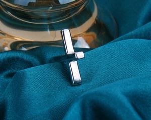 Gros plan détaillé d'une bague croix en argent S925 sur un fond élégant en velours sarcelle