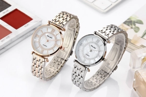 Detail showing two luxury steel quartz watches with Roman numerals and rhinestone dials