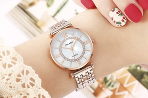 Close-up of a women's quartz watch featuring a sparkling diamond bezel and two-tone metal band