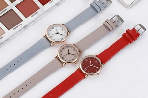 Detailed view of fashion women's quartz watches with gray, beige, and red faux leather straps