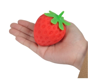 Close-up of a realistic strawberry squishy toy held in palm for stress relief