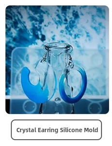 Close-up of blue resin earrings hanging on glass bottle made with DIY silicone mold