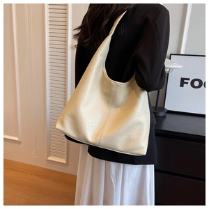 Close-up of cream lychee-grain leather tote bag showing large capacity and soft texture