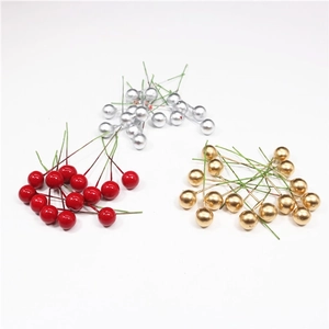 Close-up of decorative artificial Christmas berries in red, silver, and gold glossy finish