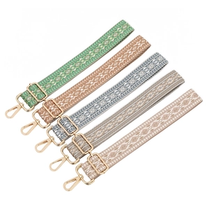 Five adjustable ethnic style guitar straps with gold hardware in various geometric patterns