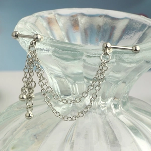 Detail of silver stainless steel industrial barbell featuring double layered hanging chains