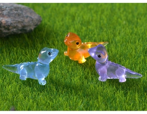 Close-up of three colorful glow-in-the-dark resin lizards on a green artificial lawn