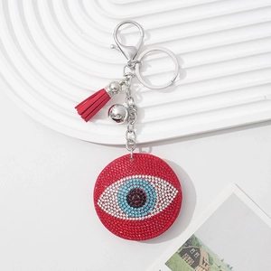 Detail of evil eye keychain with red rhinestones and matching tassel accessory
