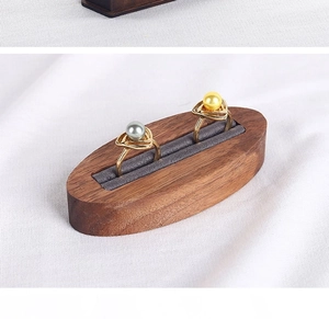 Detail of walnut wood double ring display stand with gray velvet slots and gold pearl rings