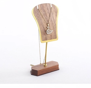 Macro detail of walnut wood and gold metal jewelry stand for necklace display