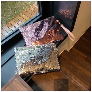 Close-up of sparkling lavender and silver sequin mini clutch bags with leather handles
