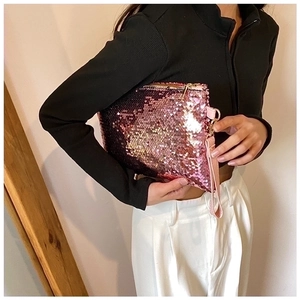 Close-up of pink sequin clutch bag with matching wristlet strap and metallic zipper