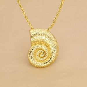 Macro shot of gold nautilus shell pendant with spiral texture on twisted rope chain