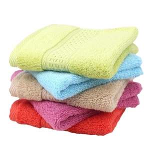 Stack of colorful pure cotton square towels with soft texture and decorative woven stripes