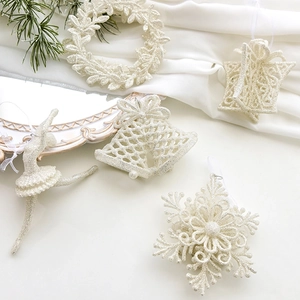 Elegant cream Christmas glitter ornaments including snowflakes and bells on silk