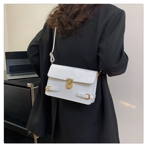 White minimalist square crossbody bag featuring a gold metal twist lock and sleek leather finish