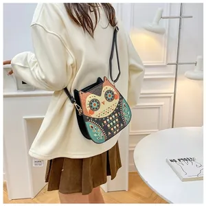 Outdoor scene of a model wearing a cute owl shaped PU leather bag with boho patterns
