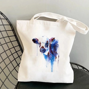 Nahaufnahme einer weißen Segeltuchtasche mit Aquarell-Welpen-Druck auf einem Gitterstuhl