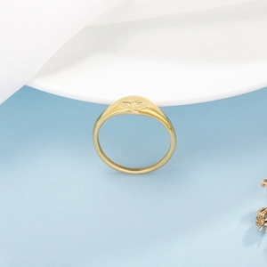 Macro detail of golden stainless steel ring with engraved starburst pattern on surface